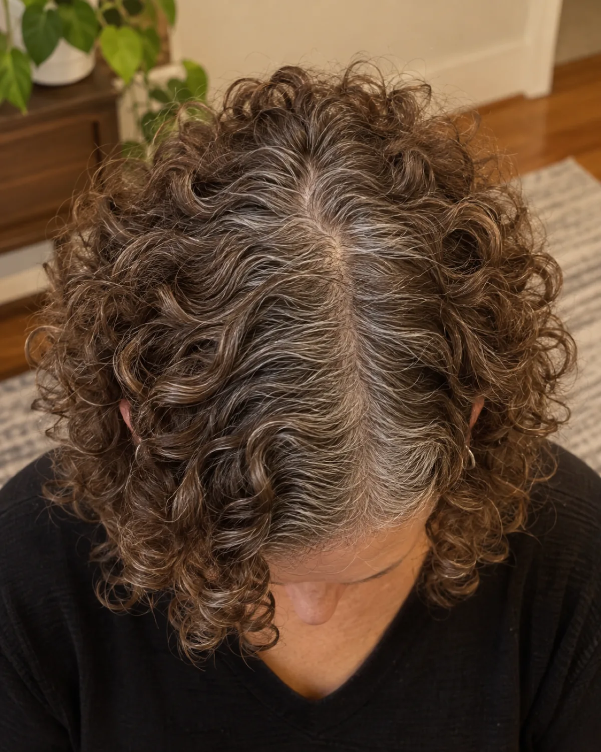 Top-down view of crown and part line showing individually shaped curls radiating outward from a center part