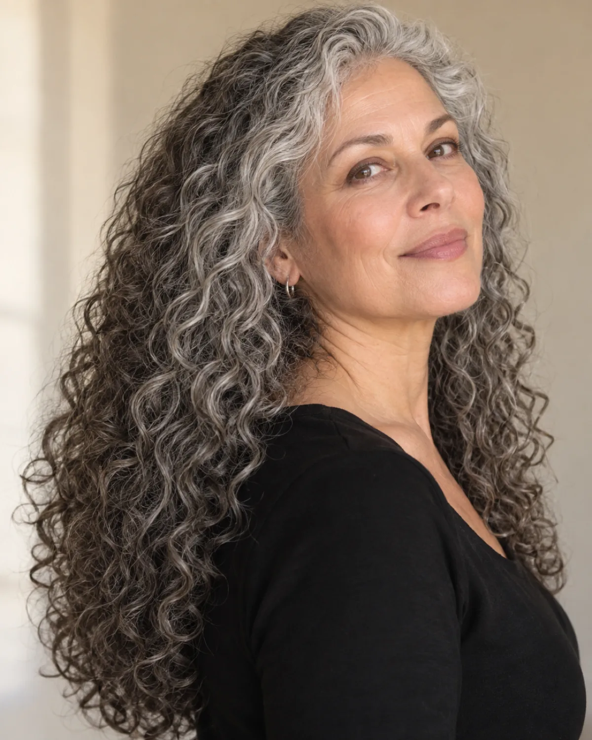 Mature woman with very long silver curls at mid-back, slight turn to camera right, minimal layering visible
