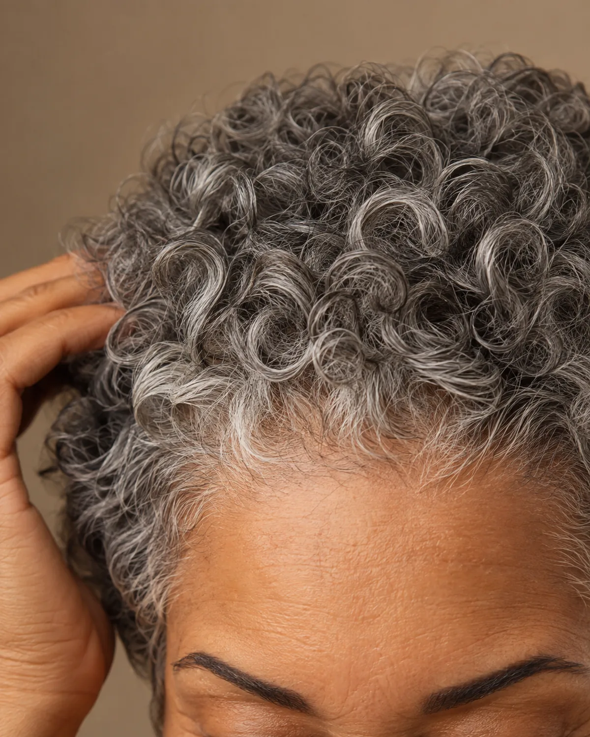 Close crop on fringe and brow line showing defined edges on short gray curls