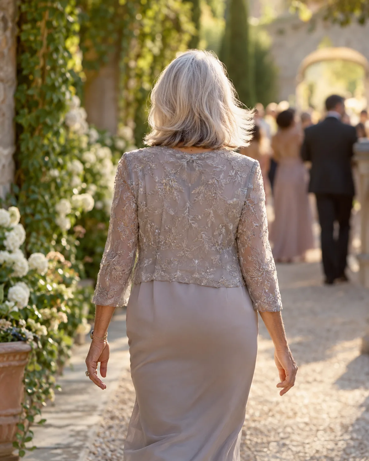 Mature woman over 60 walking away, hair in motion, shot from behind at eye level, silver hair with a volume-boosted blowout showing soft inward bends at the ends